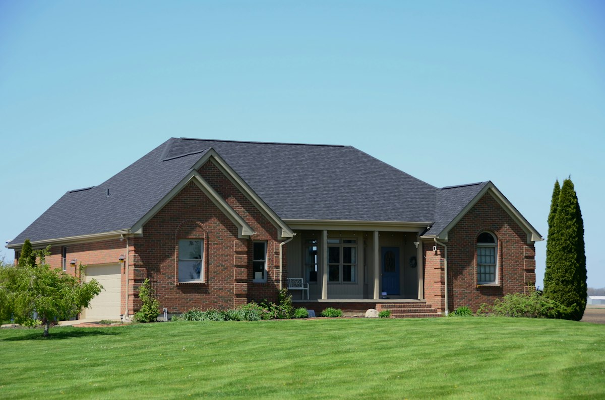 A brick family home with a green lawn